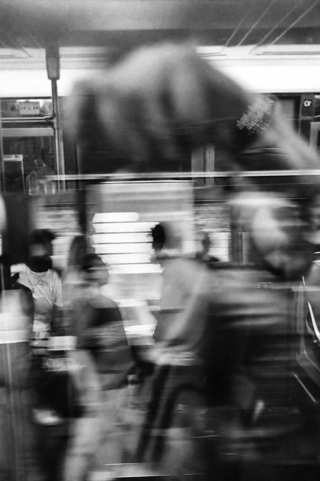 Pasajeros en movimiento entre reflejos y planos superpuestos del transporte urbano.