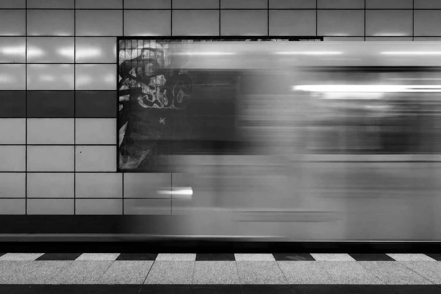 Un tren en movimiento atraviesa una estación urbana.